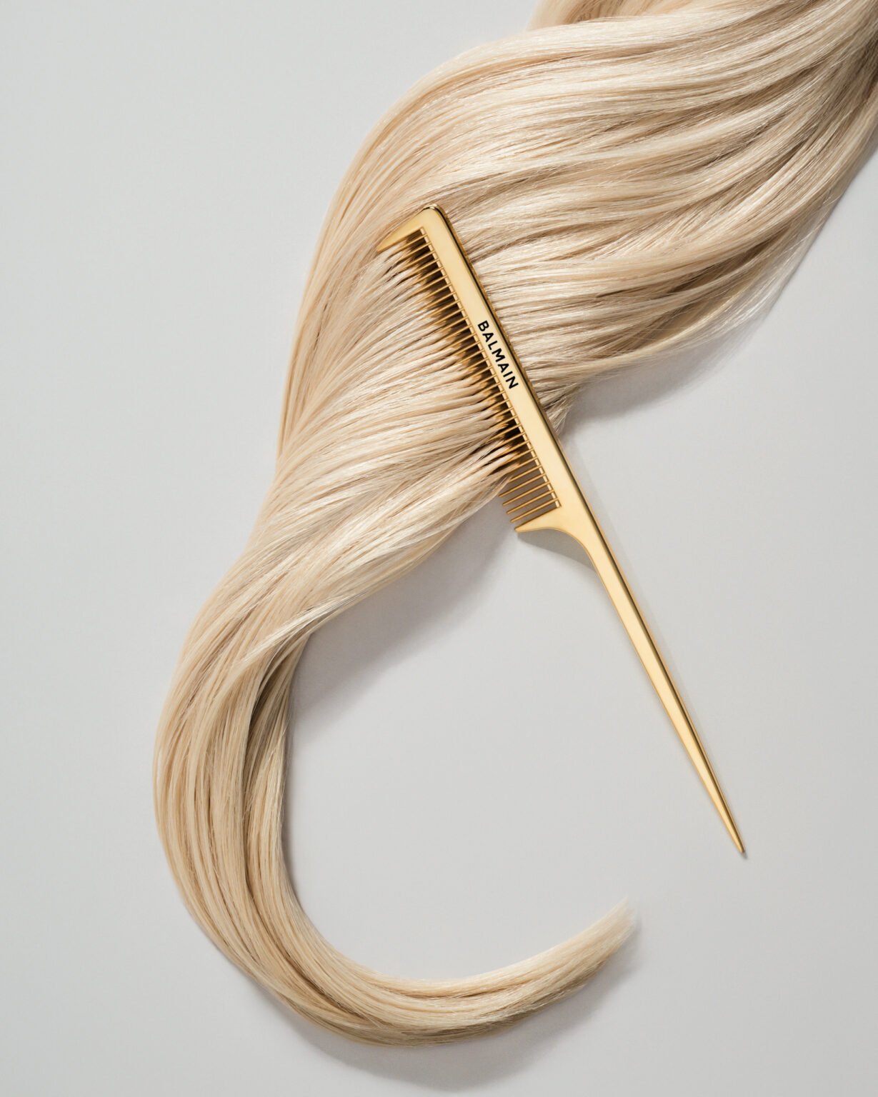 Kampagnebillede med guldfarvet kam i lyst hår